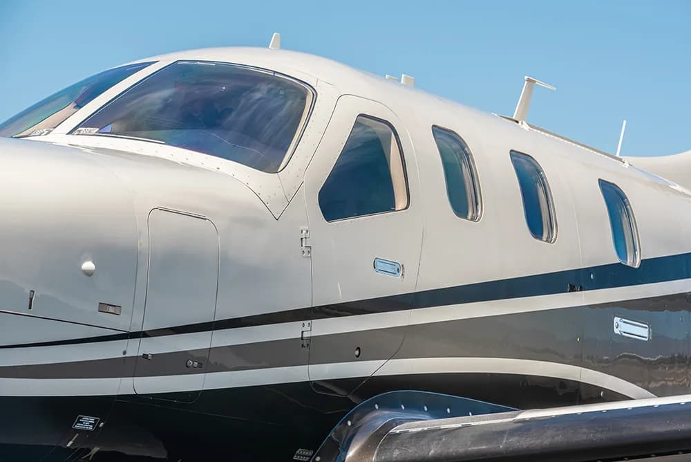 Close-up side view of the TBM 930 aircraft's cockpit and cabin windows.