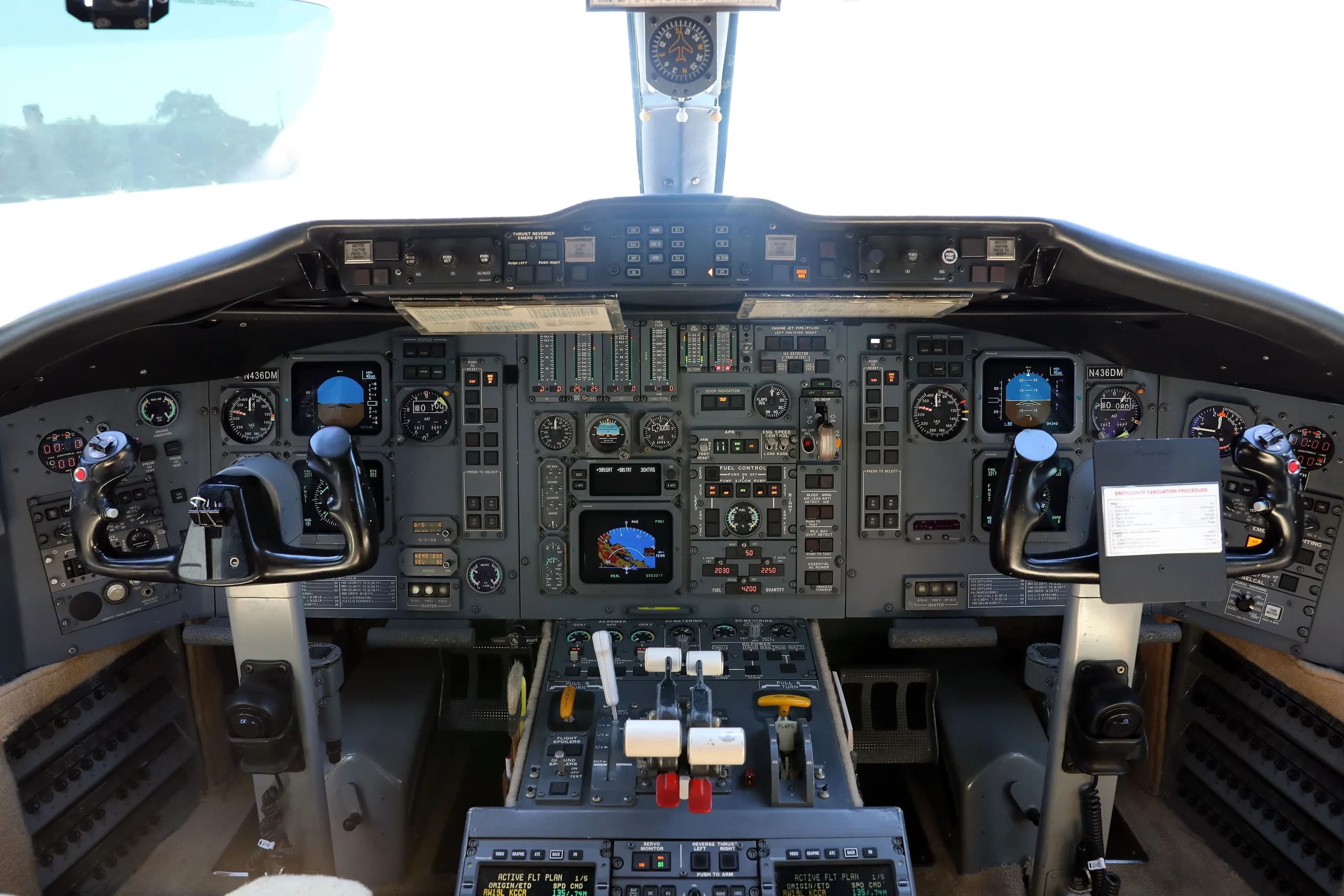 The cockpit of the Bombardier Challenger 604 aircraft, showing the instrument panel and controls.