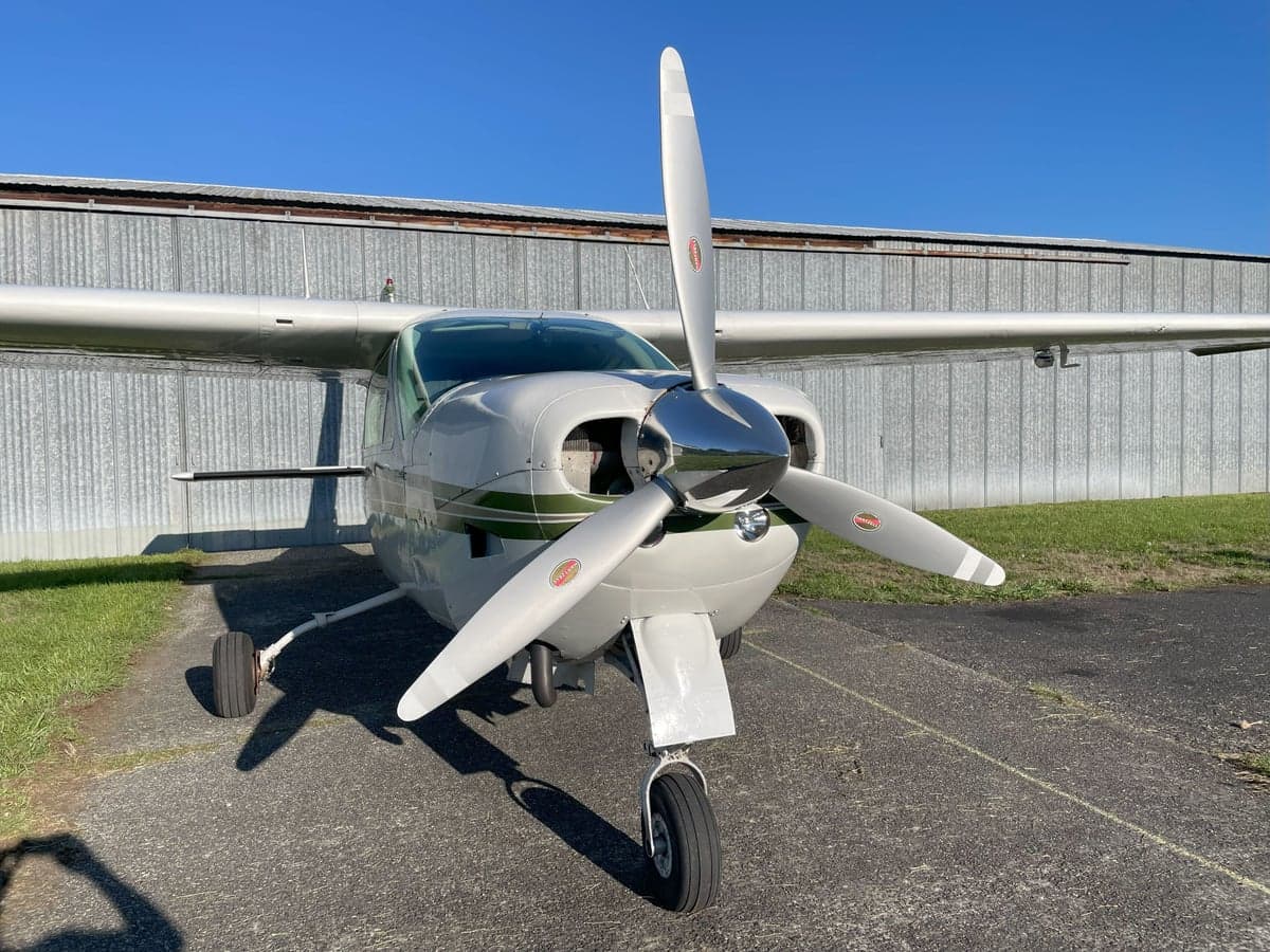 A front view of a white and green Cessna Cardinal RG II, registration N51386, parked on the tarmac.