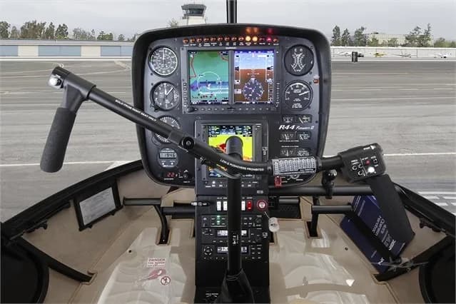 The cockpit of a Robinson R44 helicopter with modern avionics.