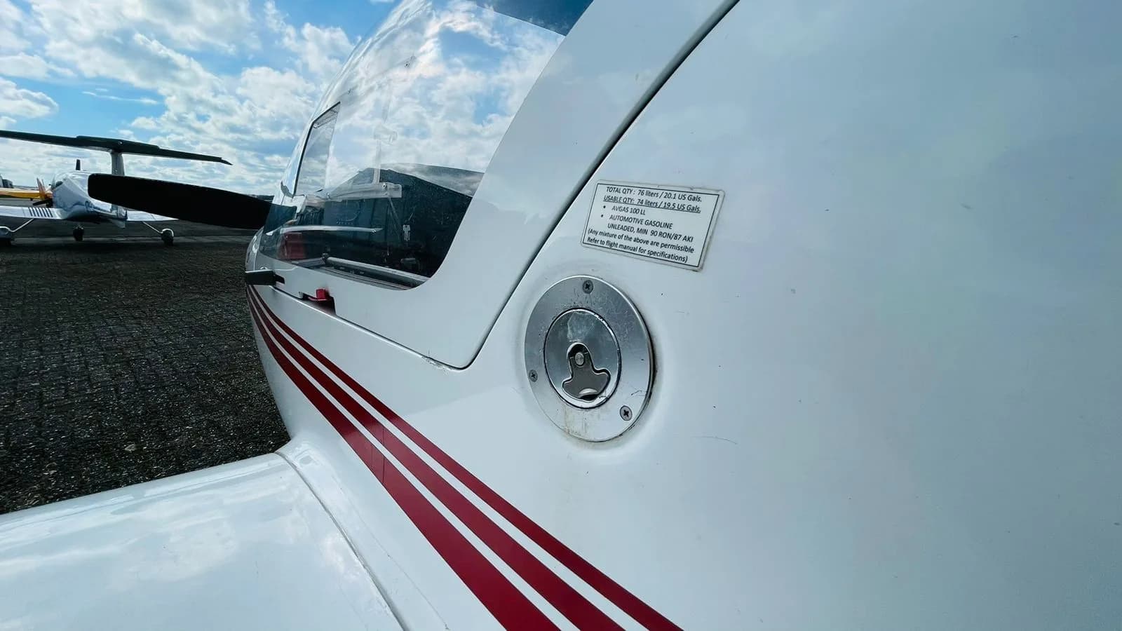Close-up of the fuel filler cap and fuel information placard on the Diamond DV20 Katana aircraft.