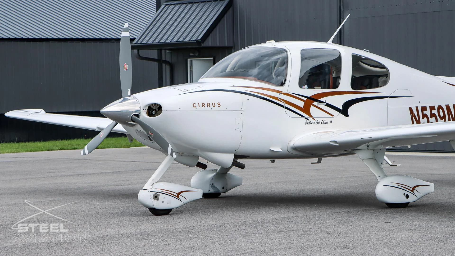 A close-up view of the nose and cockpit of a white Cirrus SR22 aircraft with N559MM registration.