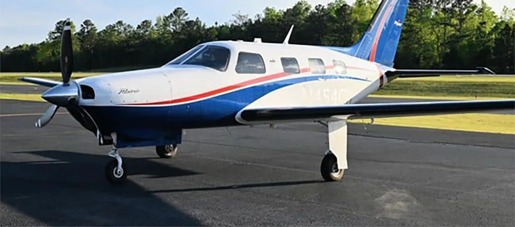 A Piper Matrix N454CW aircraft with a white, blue, and red paint scheme parked on an asphalt runway.