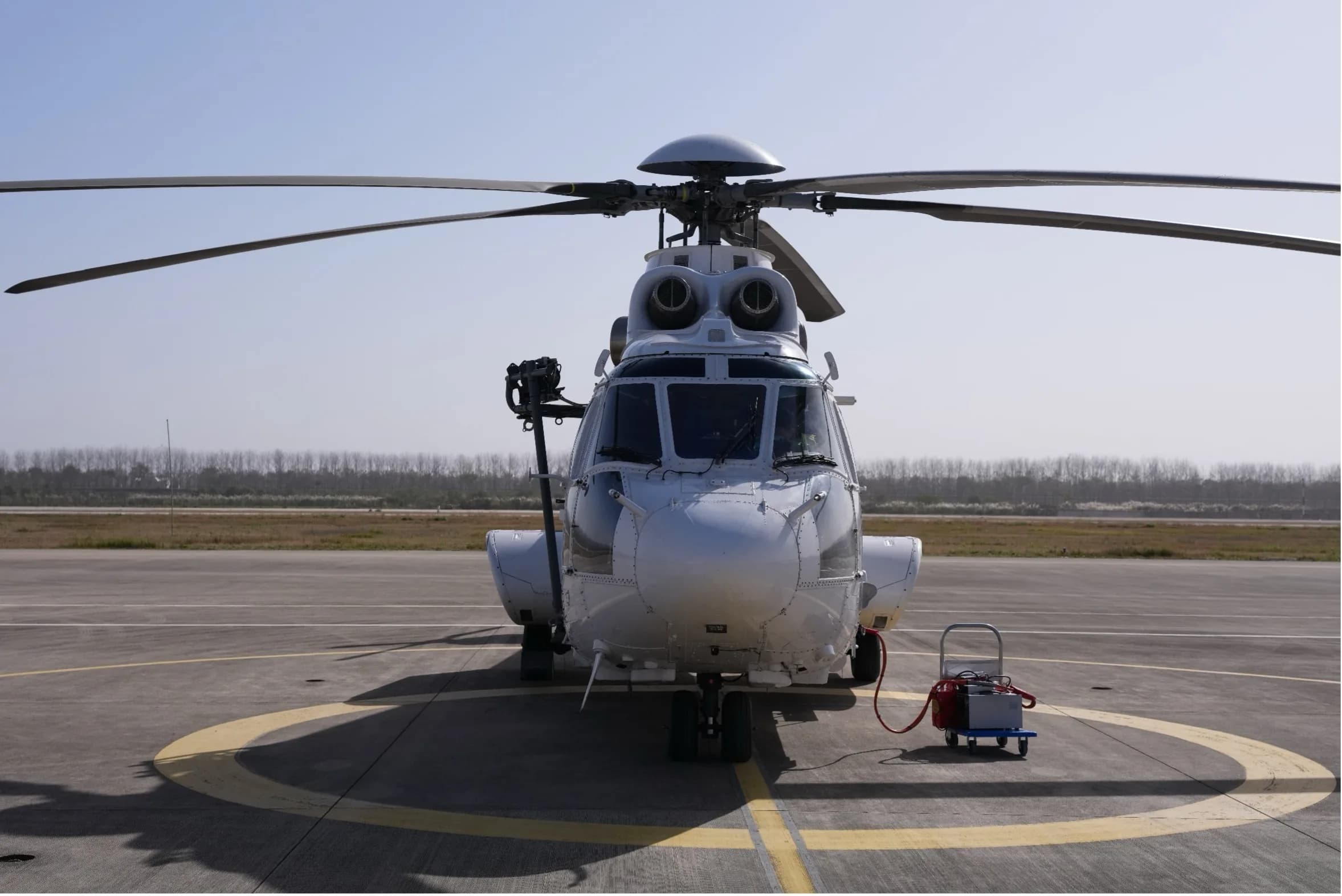 A front view of a white Airbus Helicopters H225 Super Puma on the tarmac.