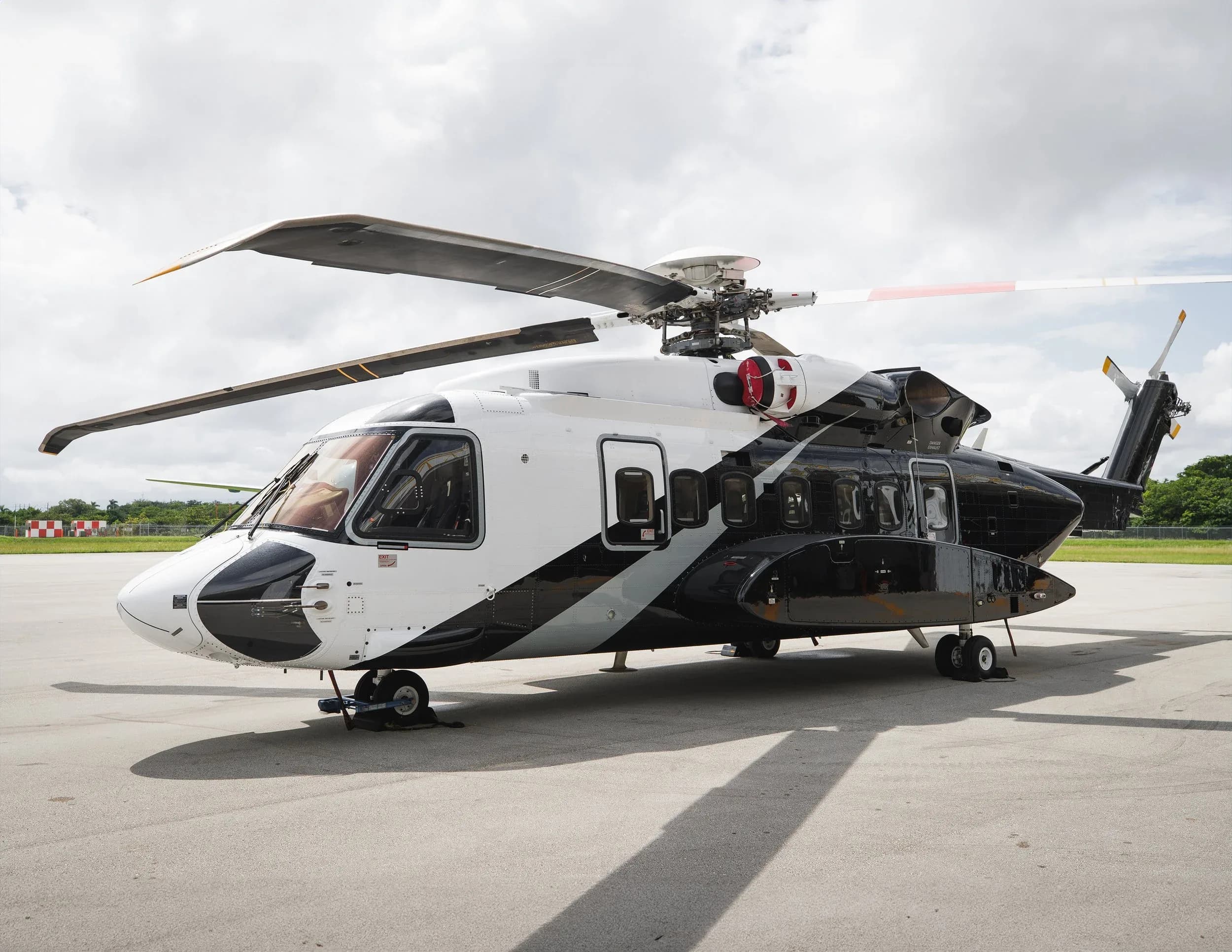 A black and white helicopter is parked on the tarmac.