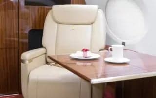 A single seat with a table and refreshments inside the aircraft.