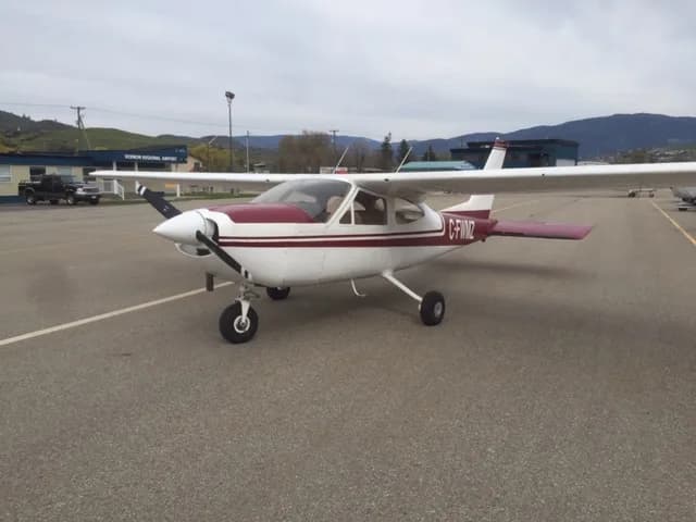 A Cessna 177 Cardinal aircraft with a maroon and white paint scheme on the tarmac at Vernon Regional Airport.