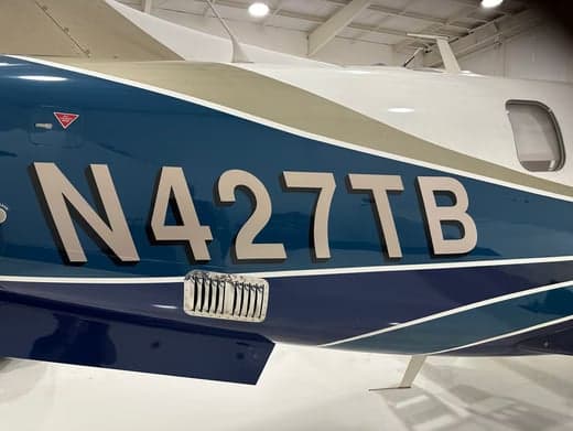Close-up of the aircraft's tail number N427TB on the fuselage.