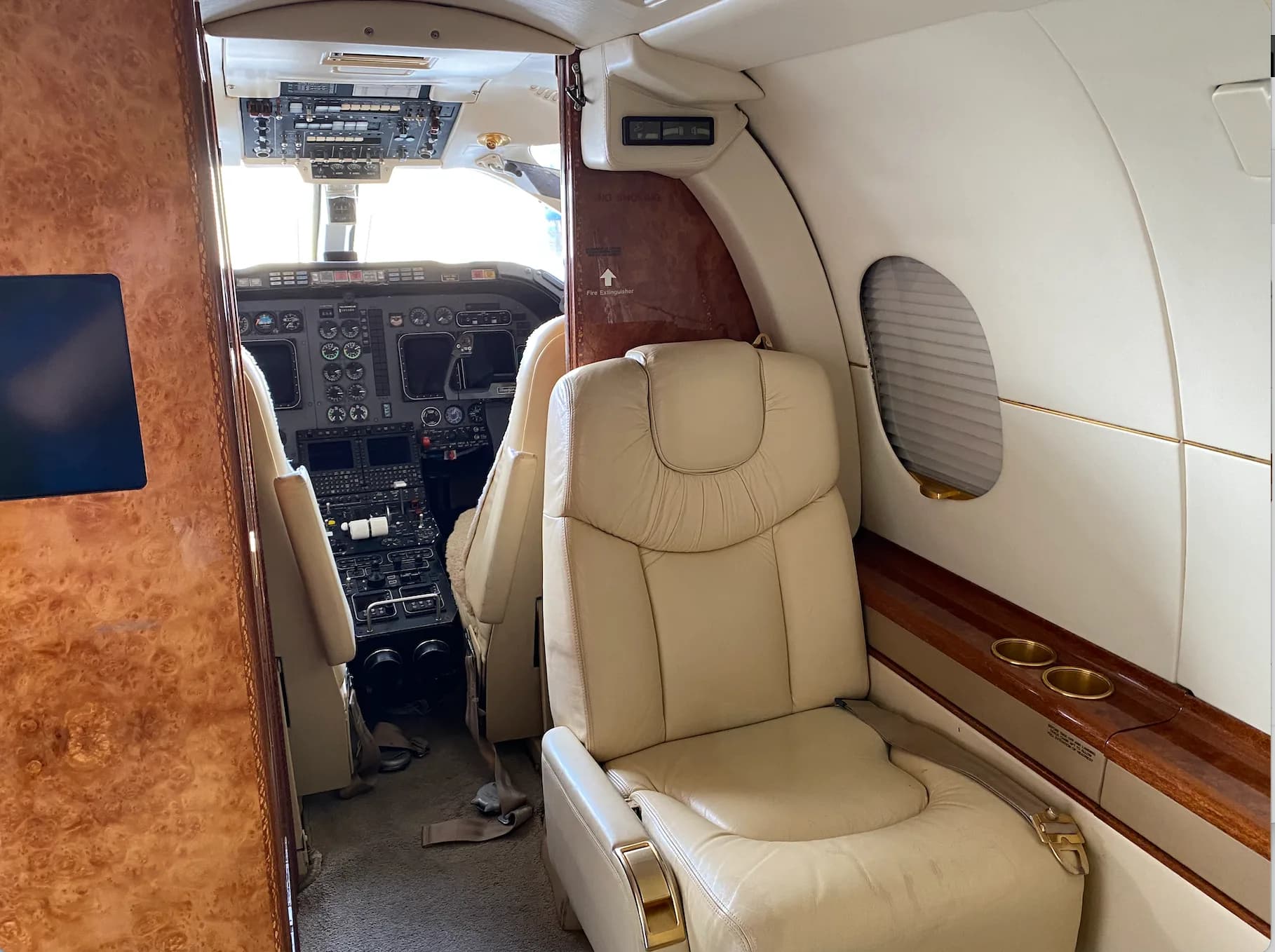 A view of the aircraft cabin showing a seat and the cockpit.