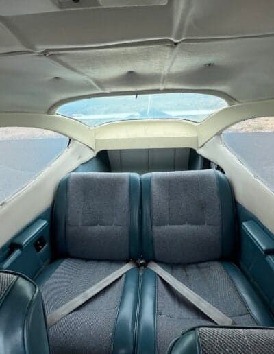 Rear cabin seats of the aircraft with seatbelts visible.