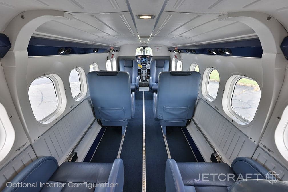View of the aircraft cabin with blue leather seats and a center aisle.