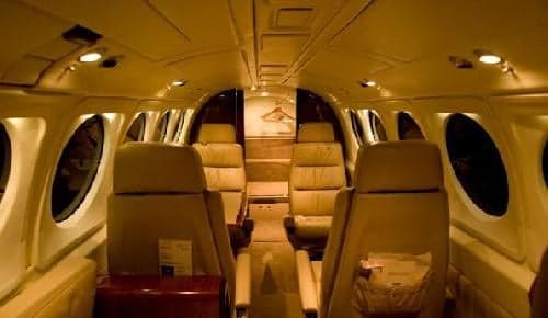 Interior view of the aircraft cabin with leather seats and oval windows.