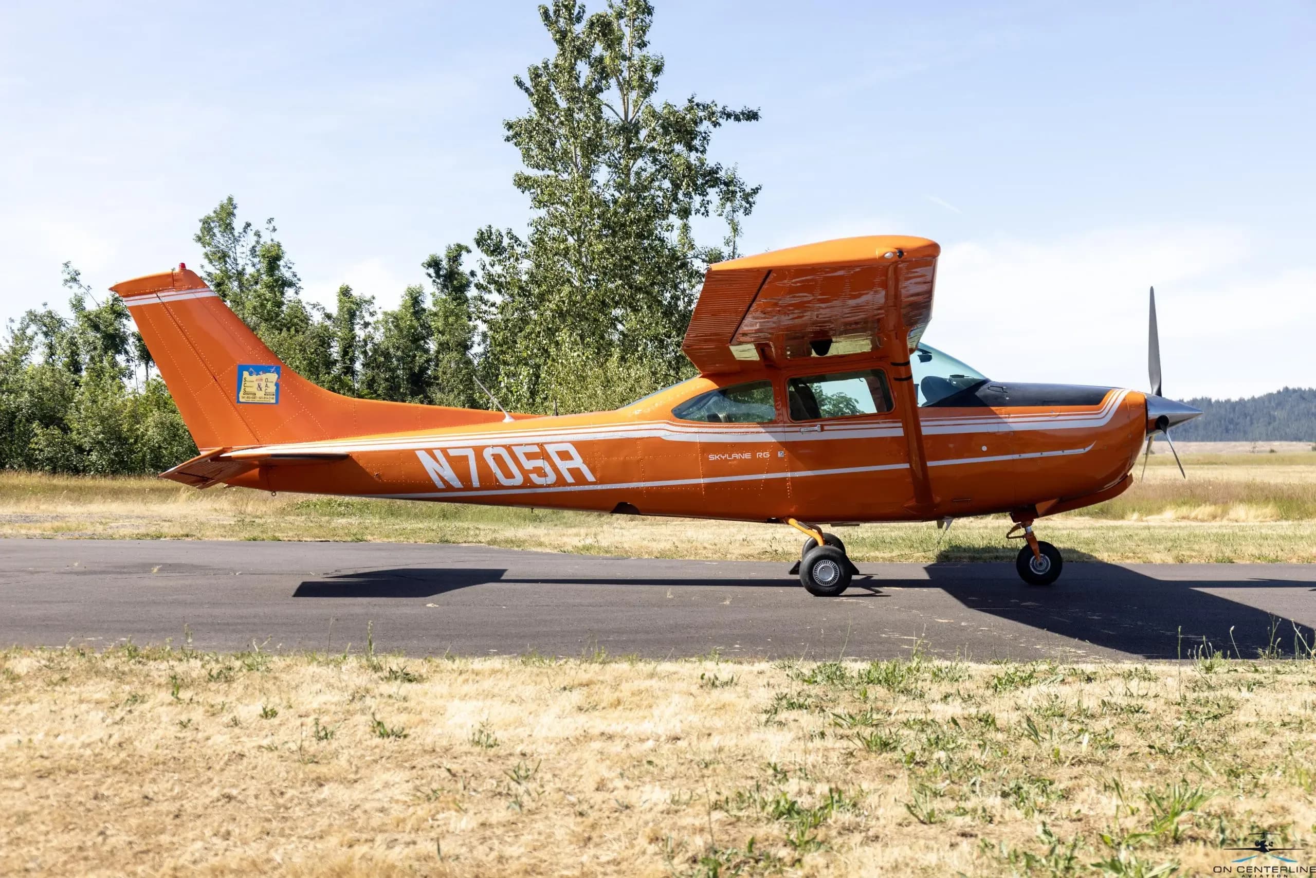 Side view of the orange and white Cessna 182 Skylane RG on the tarmac.
