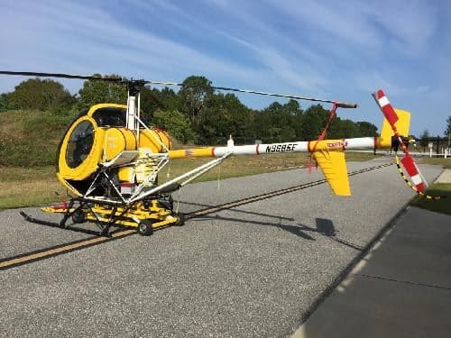 The yellow and white helicopter N9685F is parked on the tarmac.