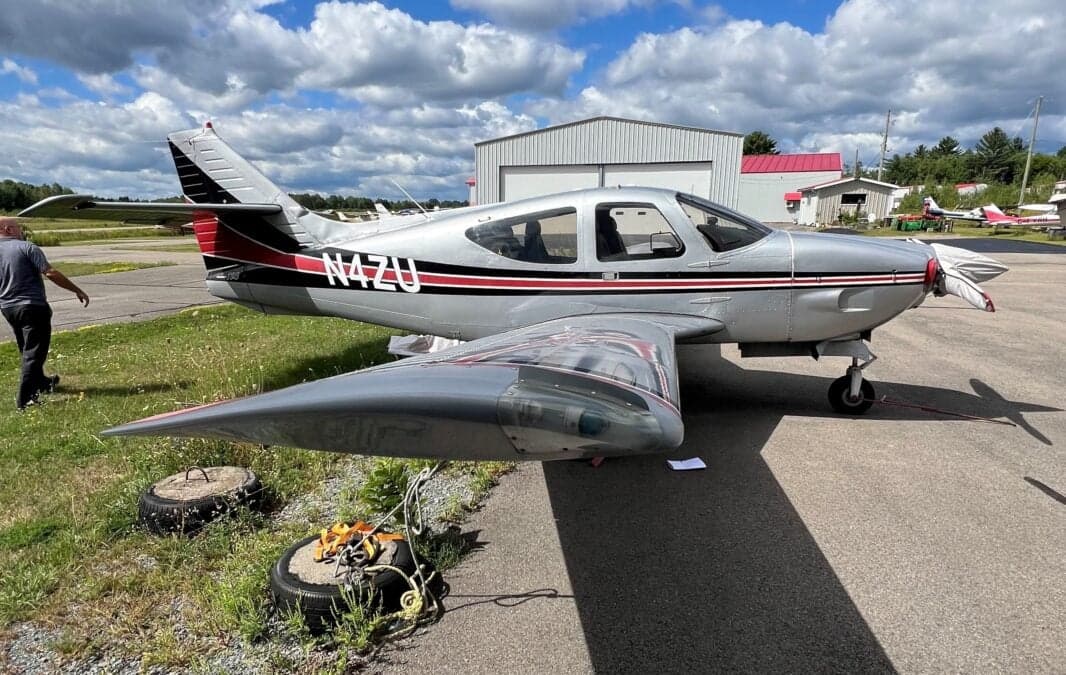 Side view of the N4ZU Mooney aircraft on the ground.