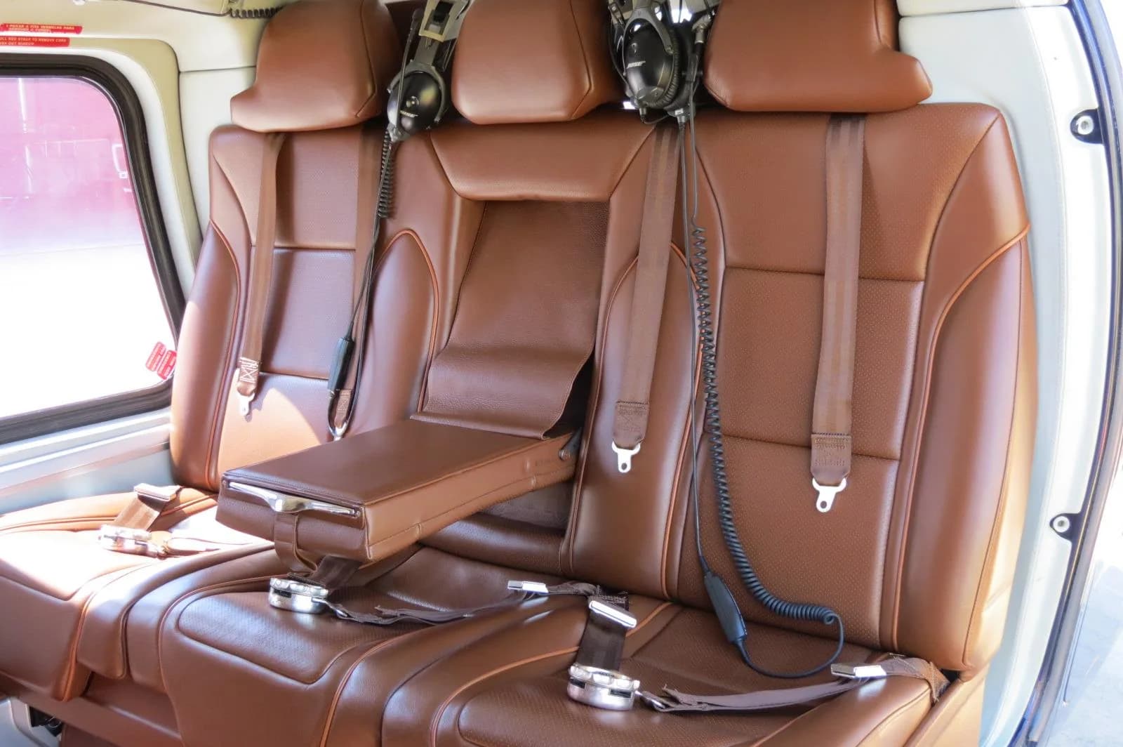 The interior of an AgustaWestland AW109 GrandNew helicopter, showing the brown leather seats.