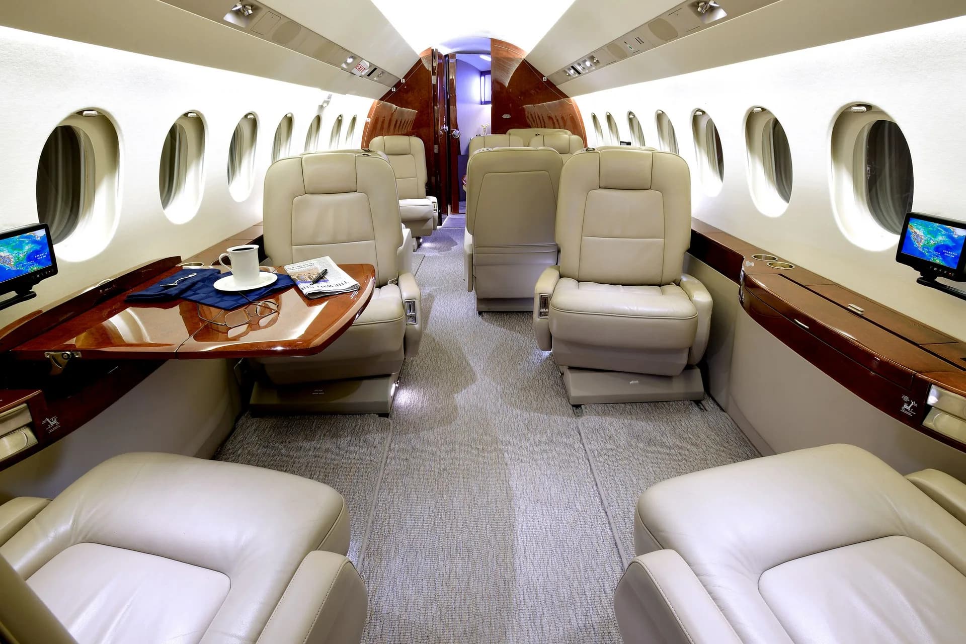 View of the aircraft's interior cabin with leather seats and tables.