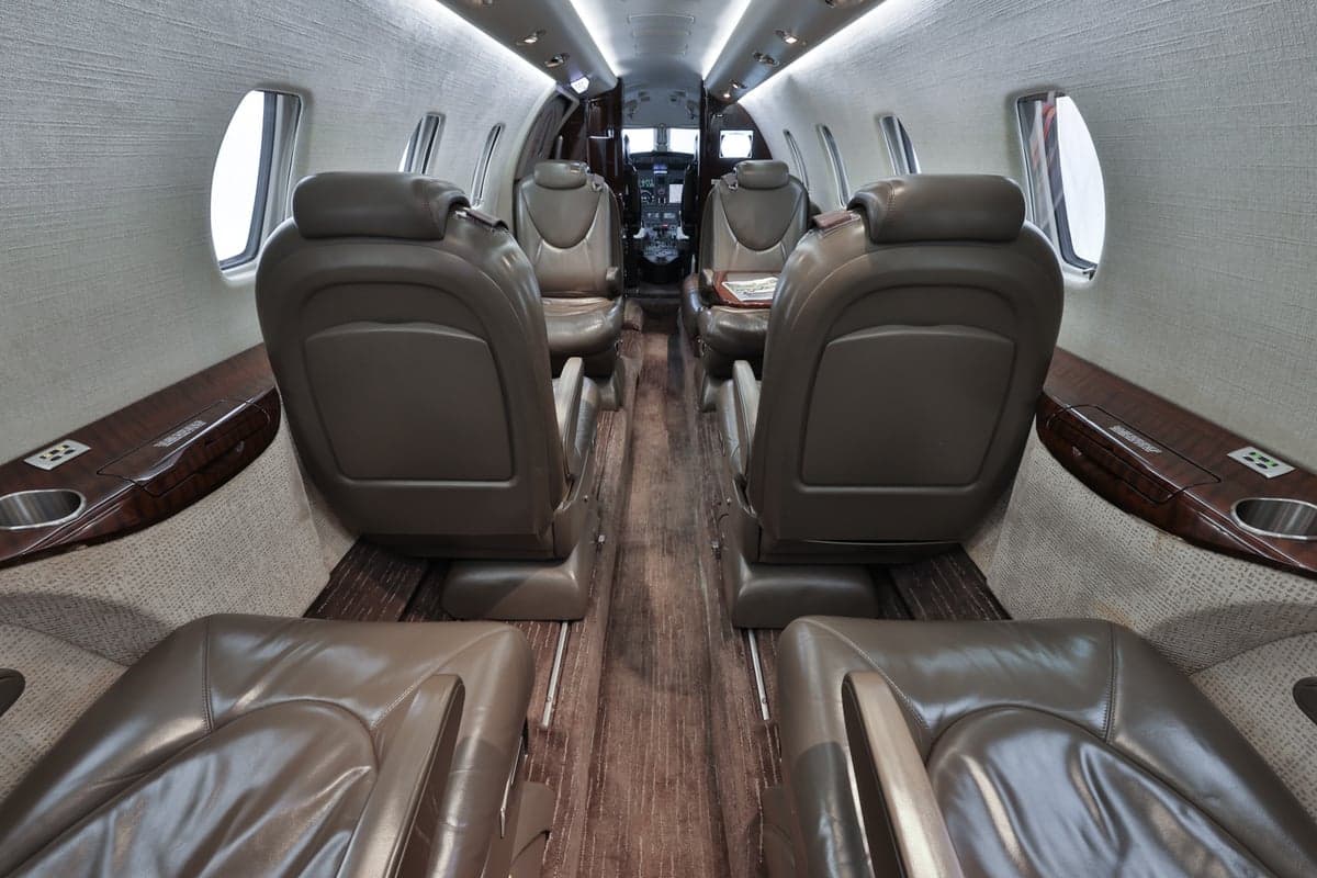 The Citation CJ3 cabin features leather seats and wood-grain accents.