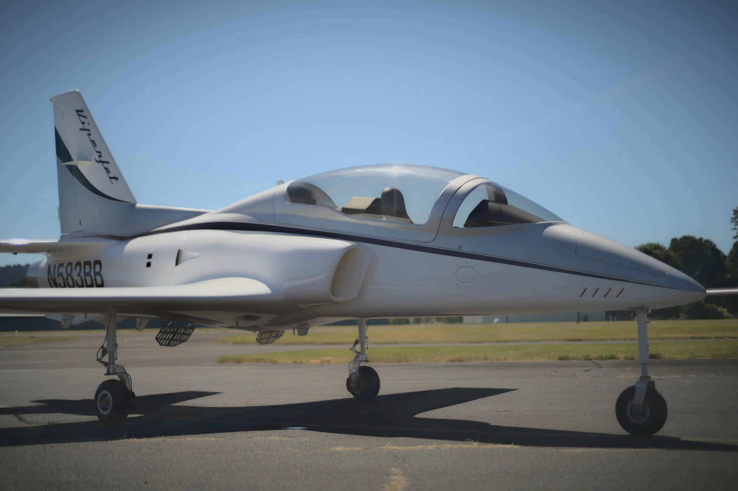 A white and silver Viperjet aircraft with its canopy closed, parked on an airfield.
