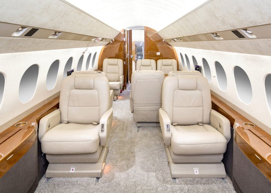 Interior view of the aircraft cabin with leather seats and wood trim.