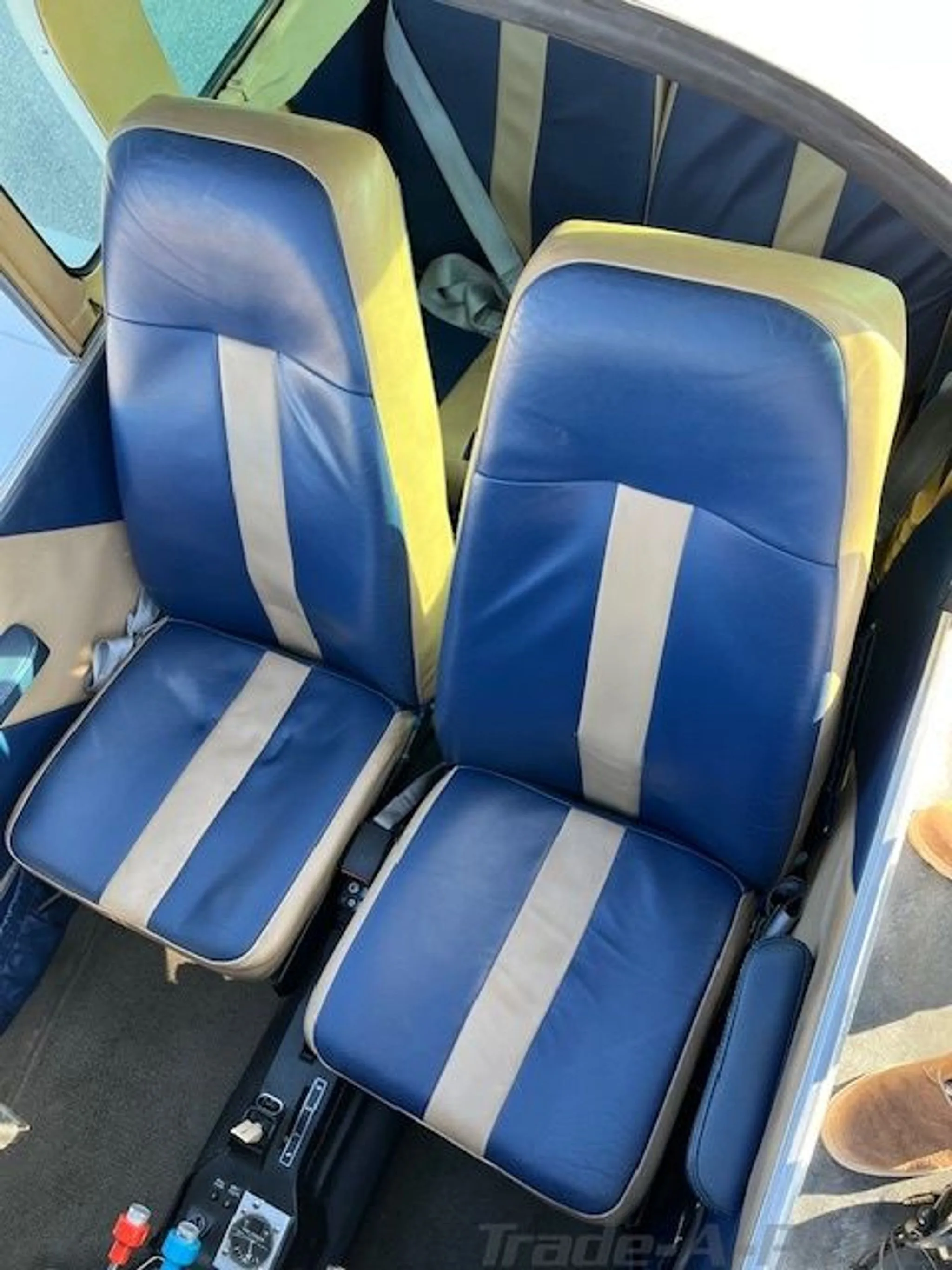 Two blue and tan striped aircraft seats in the cabin interior.