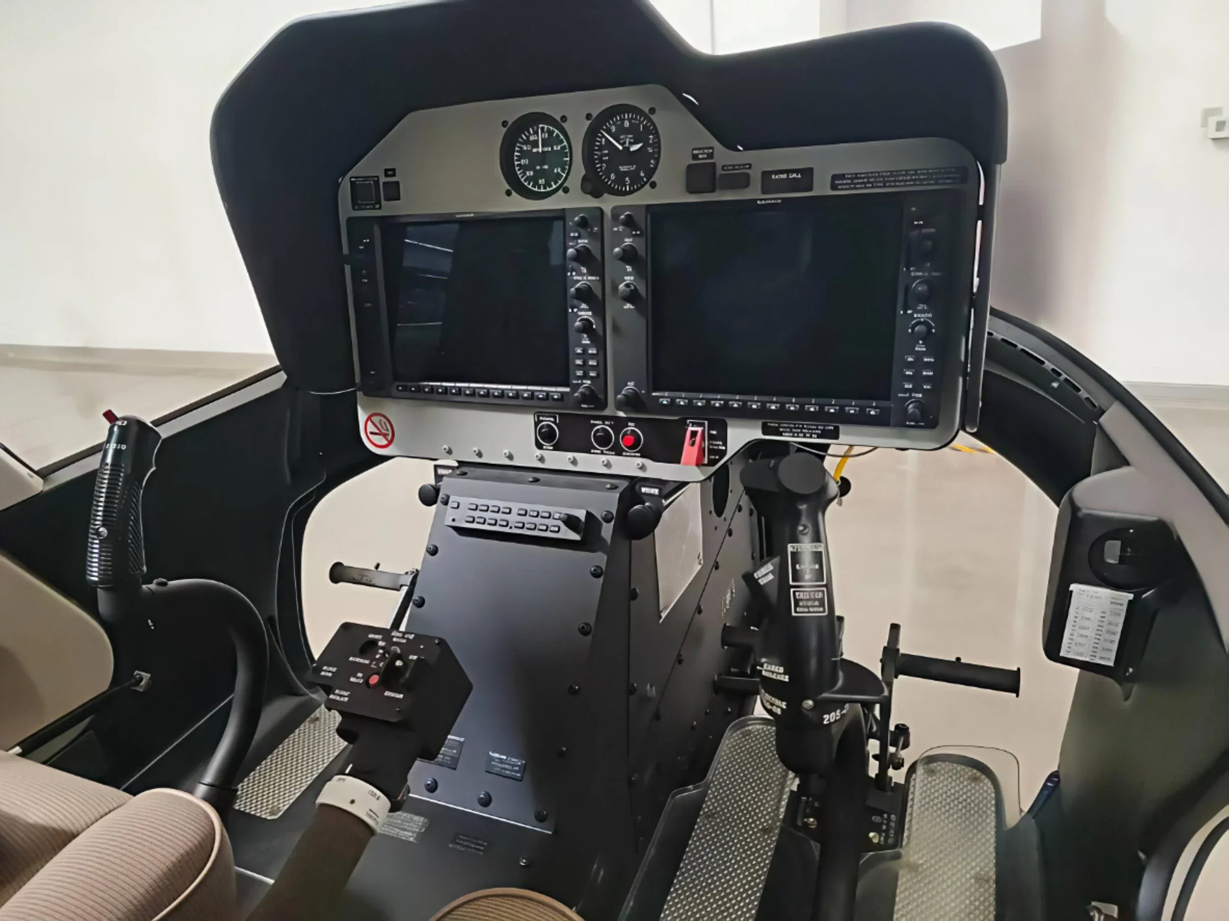 The cockpit of a helicopter, featuring a modern instrument panel with multiple digital displays and traditional gauges.