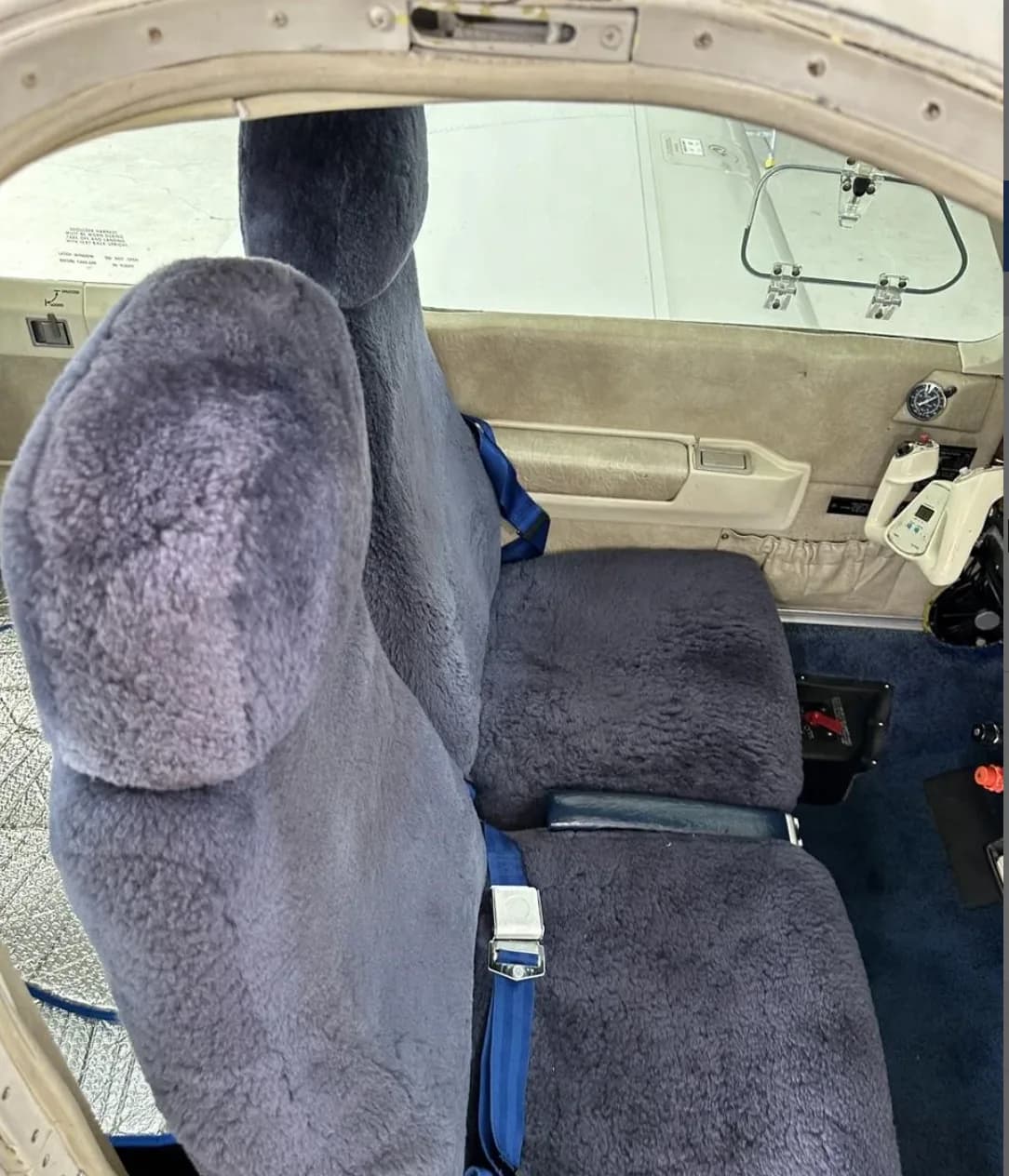 The blue sheepskin-covered pilot and co-pilot seats inside the Beechcraft Bonanza N7SP cabin.