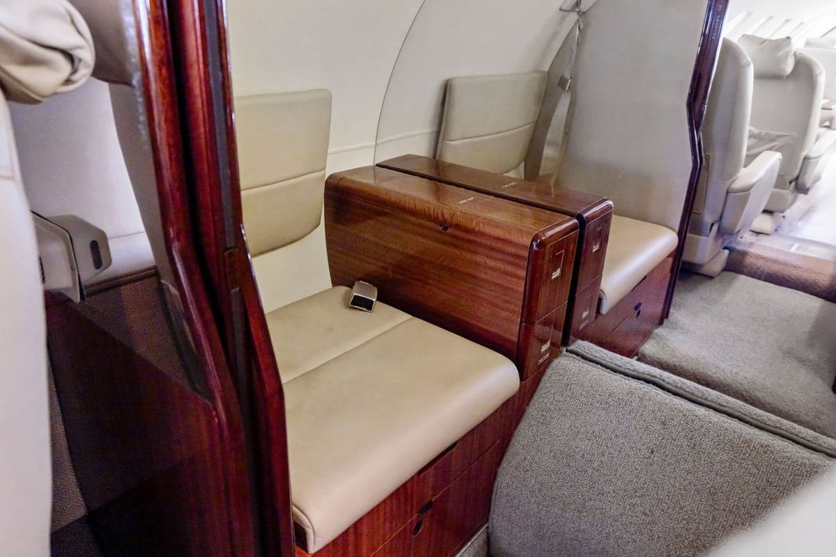 View of the aircraft interior showing leather seats and a wooden table.
