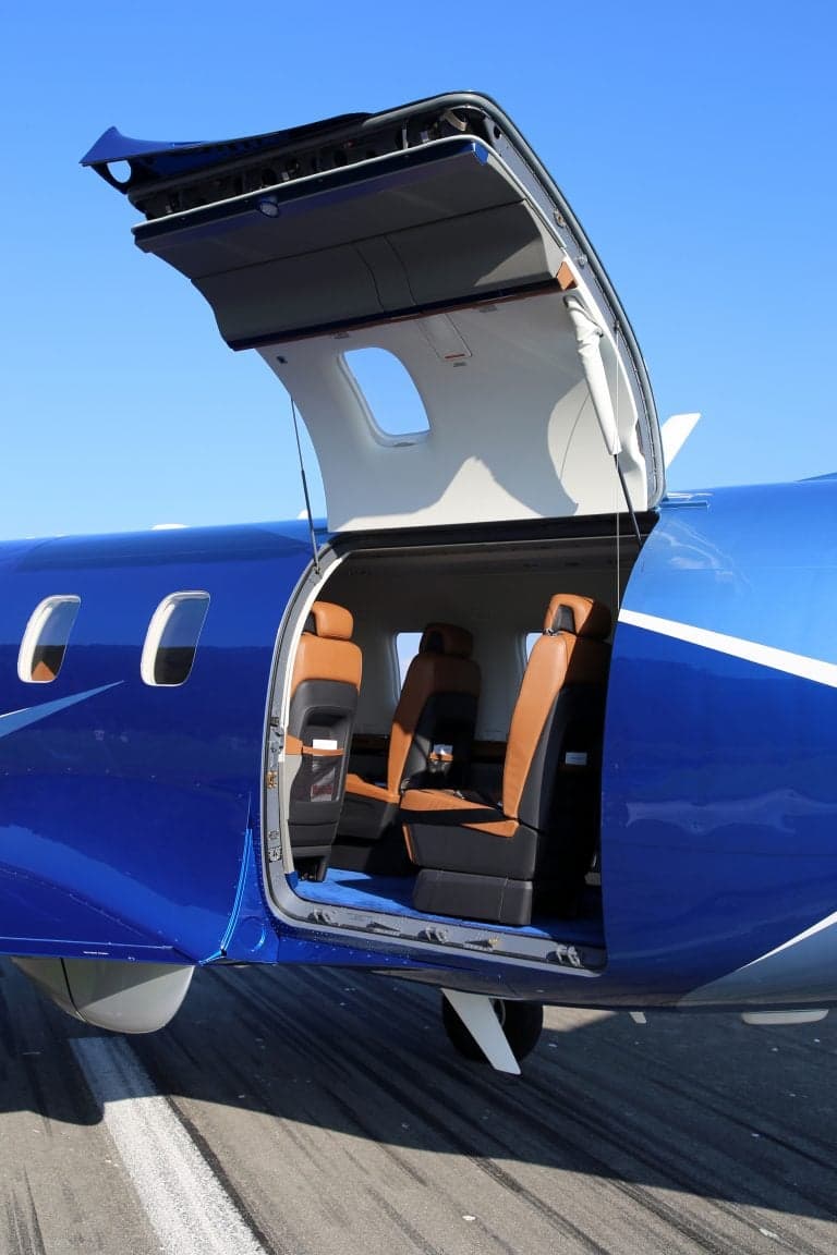 Pilatus PC-12 NGX with the rear door open, showing the interior seats.