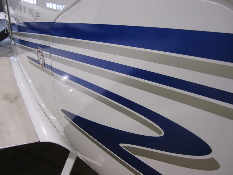 Close-up of the white fuselage of an aircraft with blue and grey stripe paint scheme.