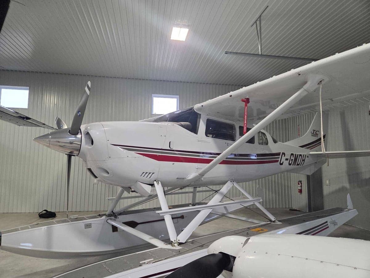 Side view of a Cessna Caravan floatplane in a hangar.