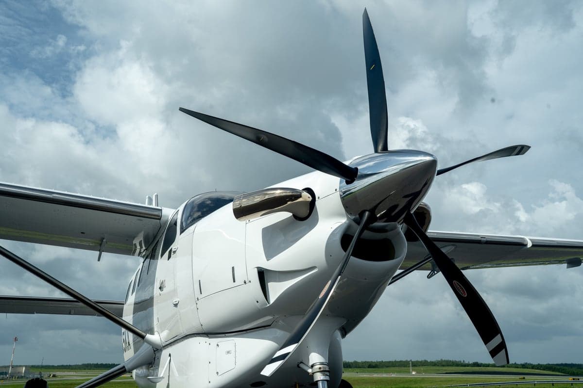 A close-up view of the propeller and nose of the white Quest Kodiak 100 aircraft, N355KA.