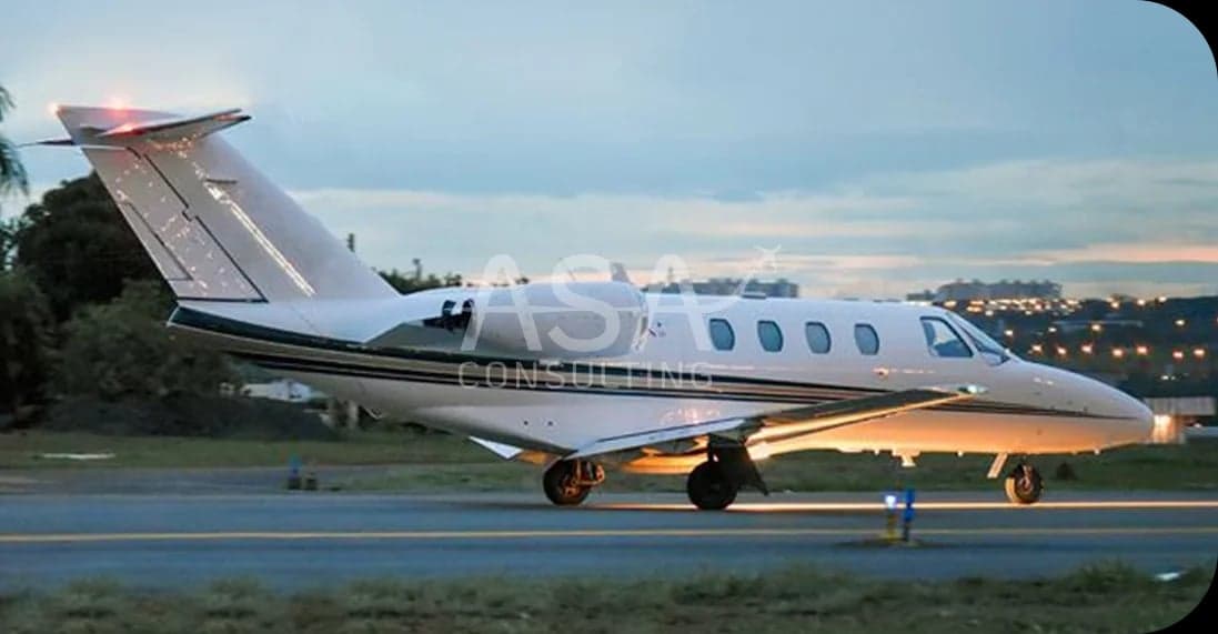 A white Cessna Citation jet on the runway at dusk.