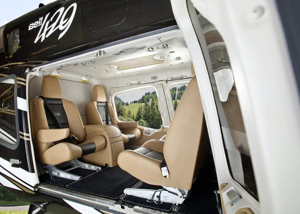 Interior view of a Bell 429 helicopter with tan leather seats.