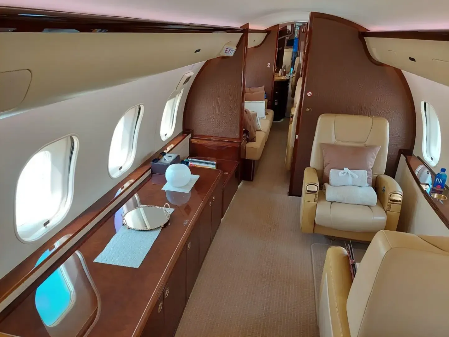 The interior of a Bombardier Global Express business jet showing the seating arrangement and amenities.