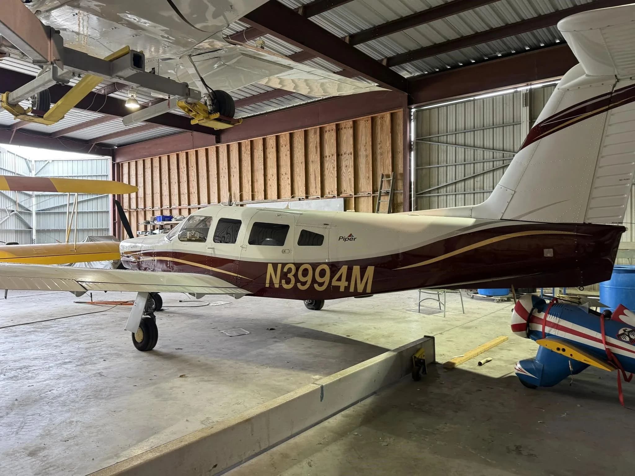 A full side view of the Piper Lance II aircraft N3994M, parked in a hangar.