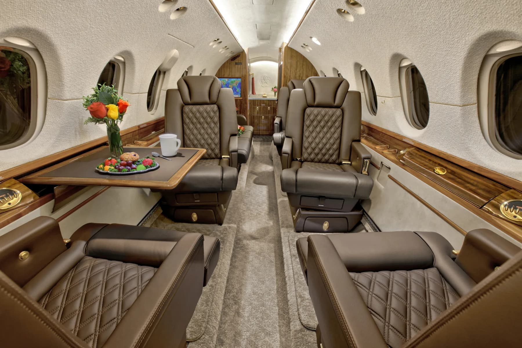 View of the aircraft's interior cabin with leather seats and tables.