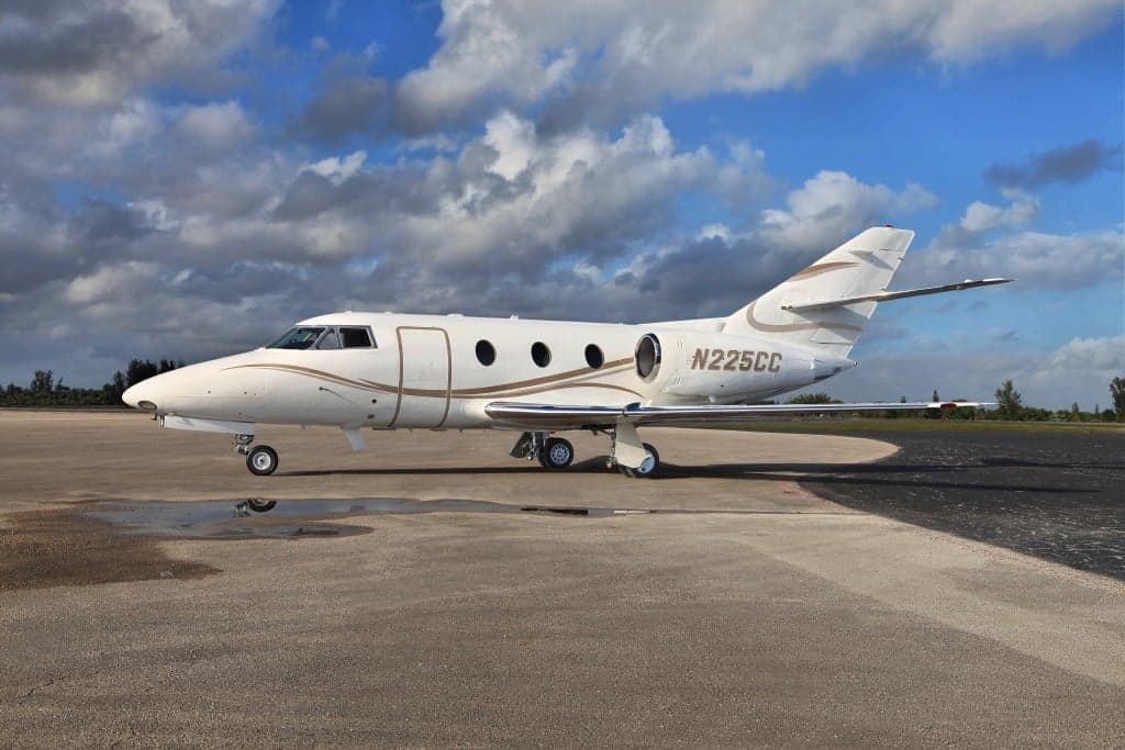Side view of a white and gold Hawker 4000 aircraft with registration N225CC on the tarmac.