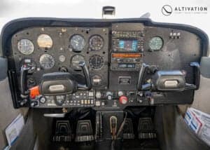 Cessna 172 Skyhawk on the tarmac with reflection in water.