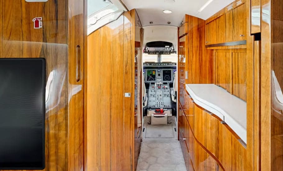 A view down the aisle of the aircraft cabin towards the cockpit.