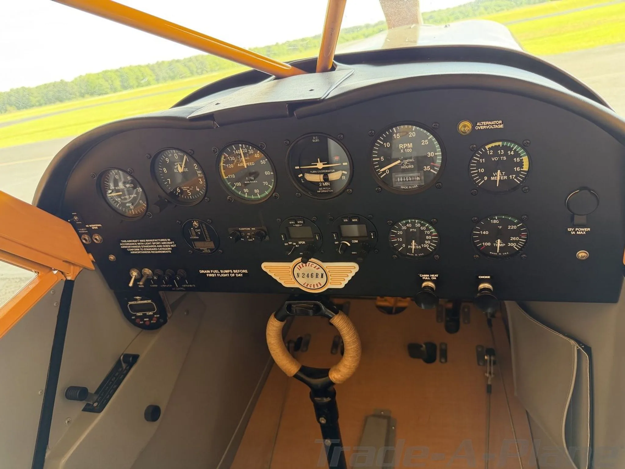 The cockpit instrument panel of the American Legend Cub aircraft, featuring analog gauges and a control stick.