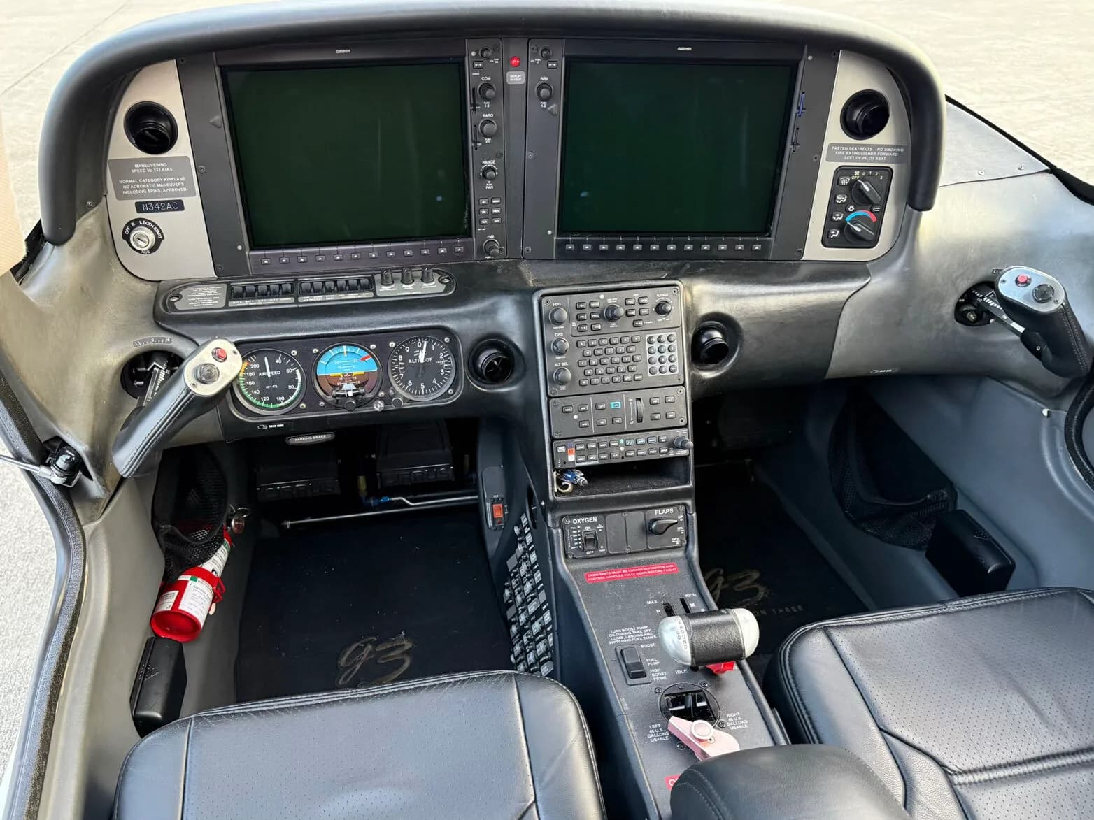 The cockpit of a Cirrus SR22 aircraft, featuring two large display screens and traditional gauges.