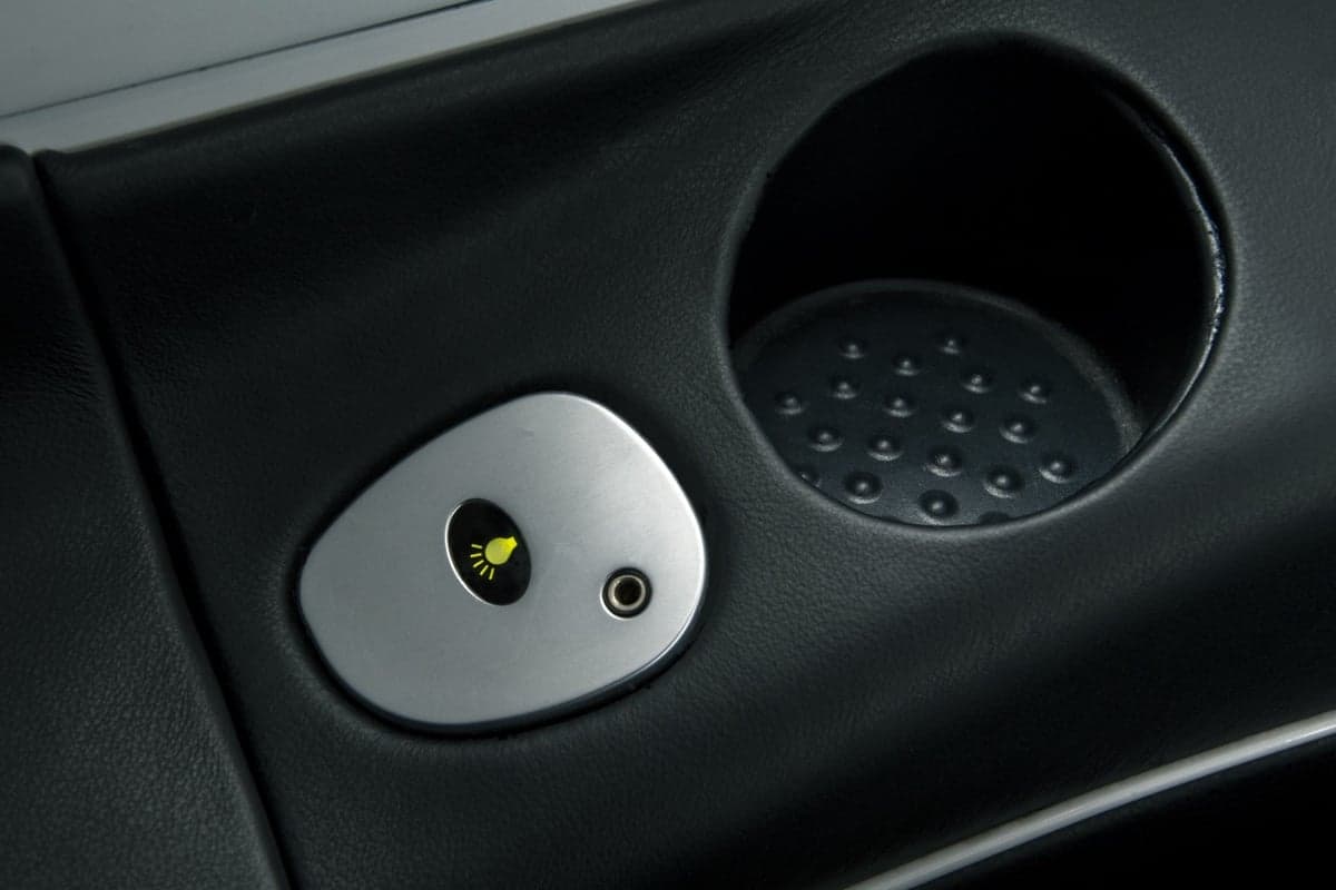 Close-up of an interior panel with a light and a cup holder.