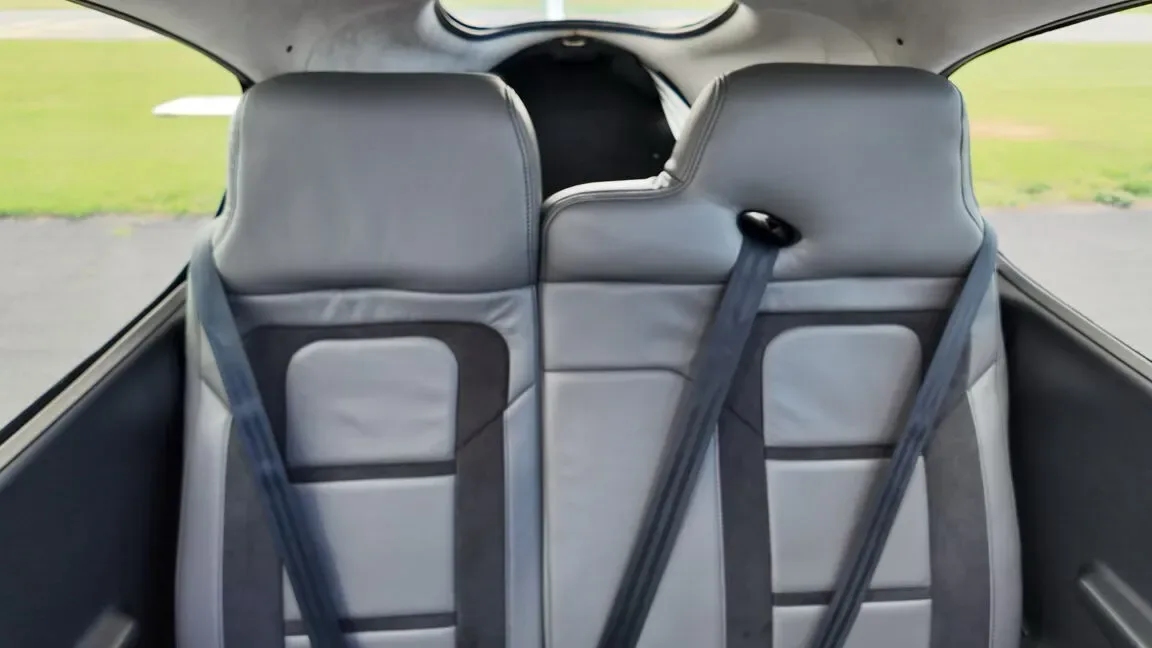 A view from the rear of the aircraft cabin showing the gray and dark gray passenger seats.