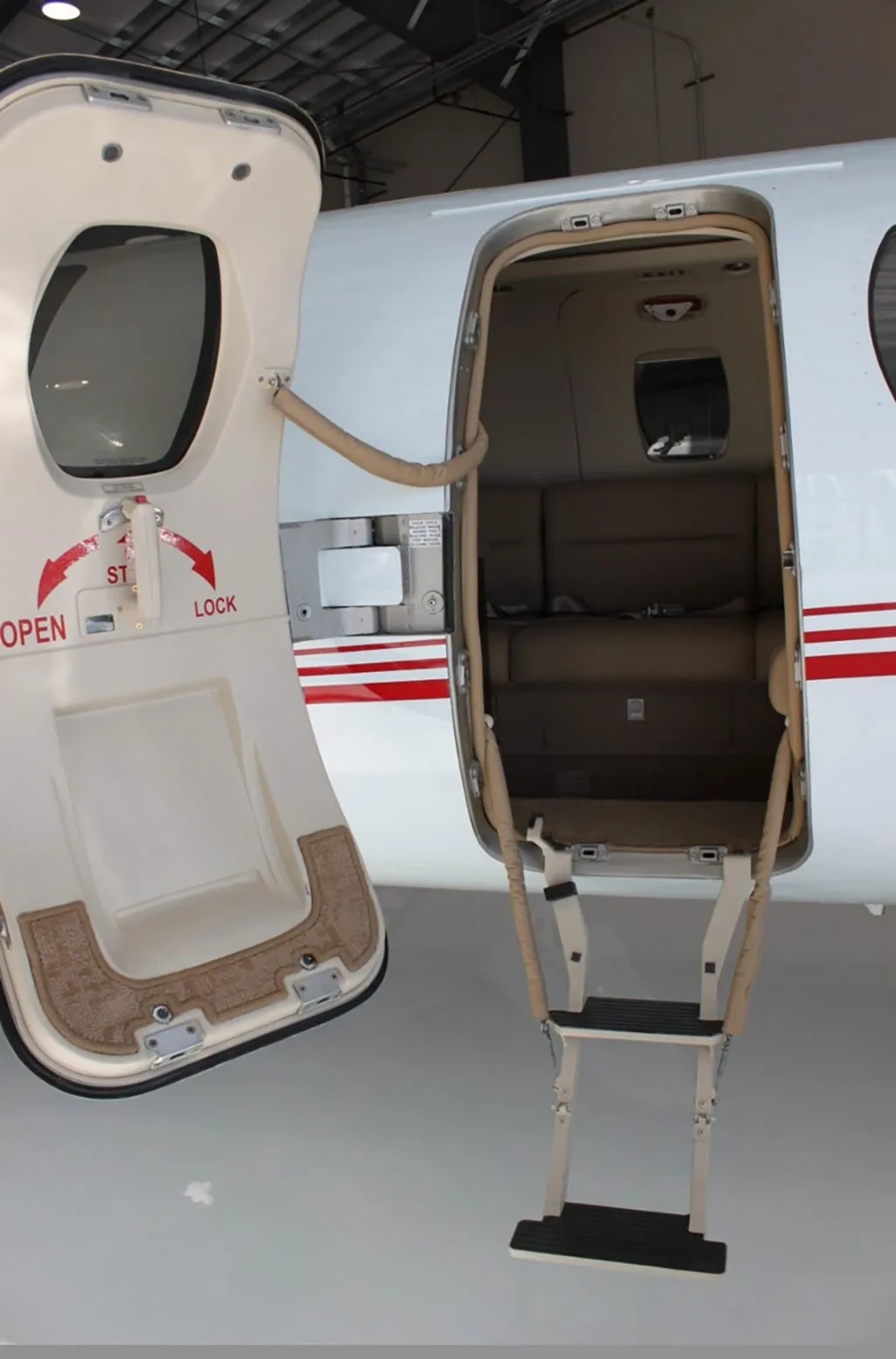 The open main cabin door with integrated airstairs of a white Cessna Citation aircraft.