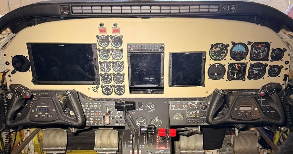 Aircraft cockpit instrument panel with Garmin displays and controls.