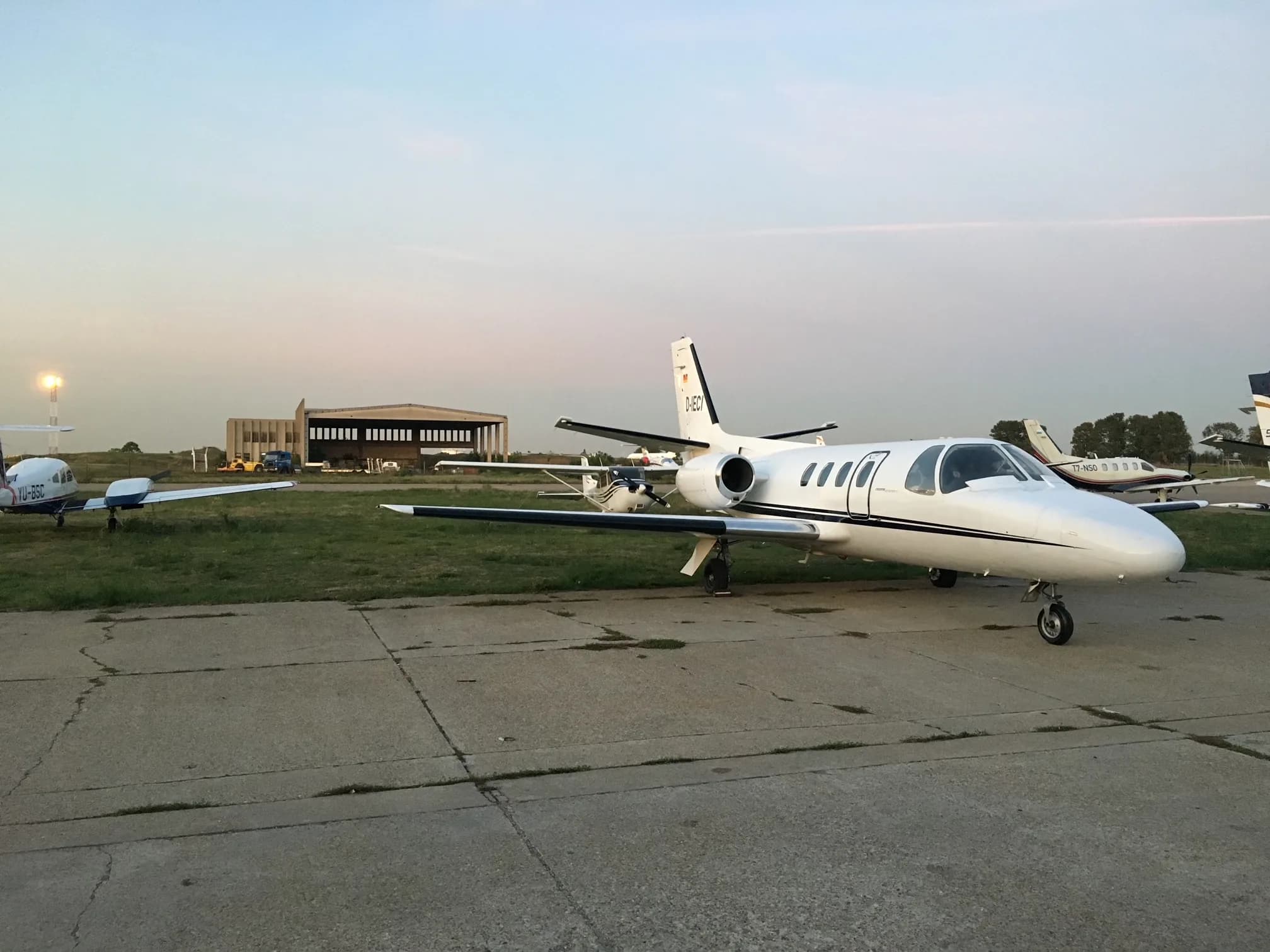 A Cessna Citation Mustang aircraft, registration D-IECI, parked on the tarmac with other aircraft in the background.