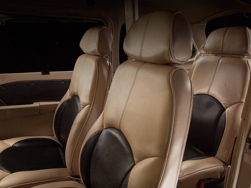 Two rows of tan and black leather aircraft cabin seats.
