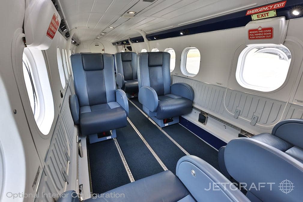 View of the aircraft cabin with blue leather seats and emergency exit signs.
