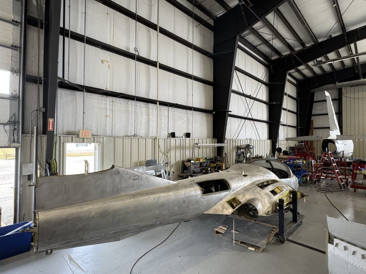 A partially disassembled aircraft in a hangar, showing the fuselage.